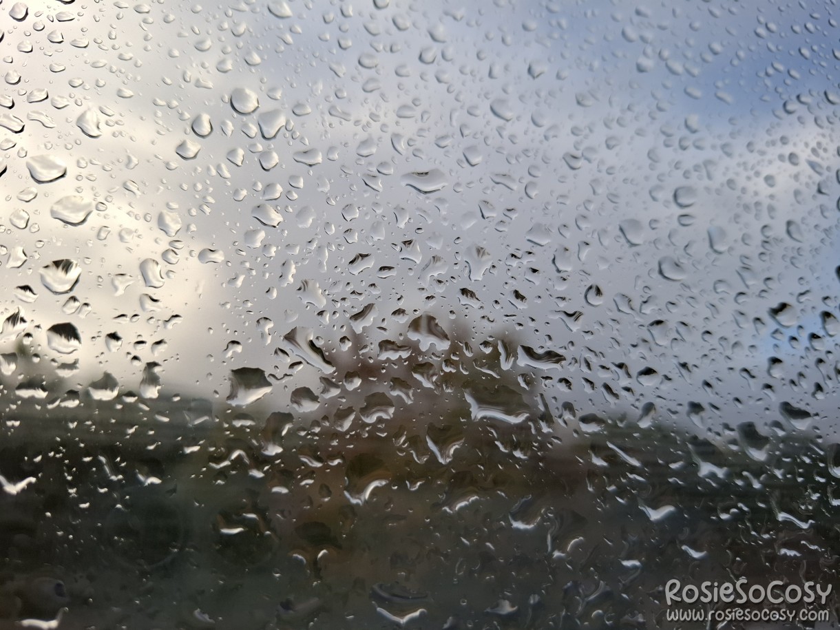 A photograph of a window with water droplets on it.